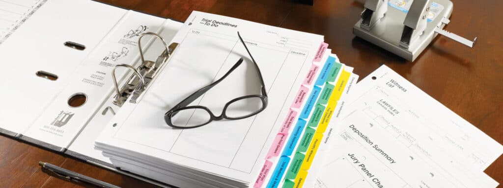 A Glasses is placed bundle of papers on desk